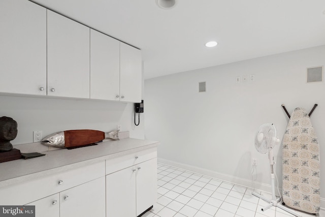 kitchen featuring light tile floors and white cabinetry