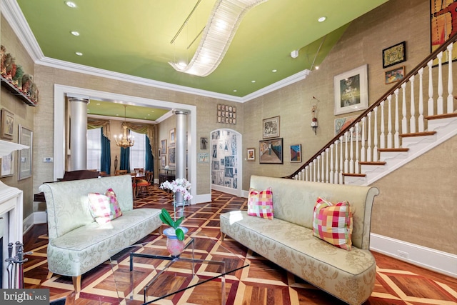 living room featuring dark parquet floors, ornamental molding, ornate columns, and a chandelier