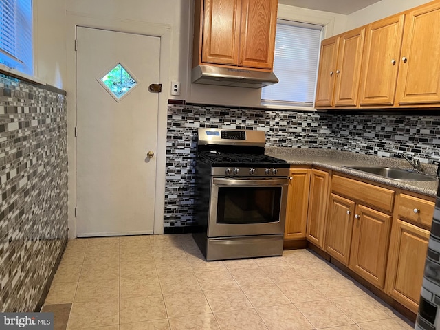 kitchen with sink, backsplash, stainless steel gas stove, and light tile floors