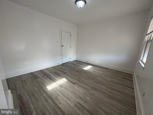 spare room with dark hardwood / wood-style flooring