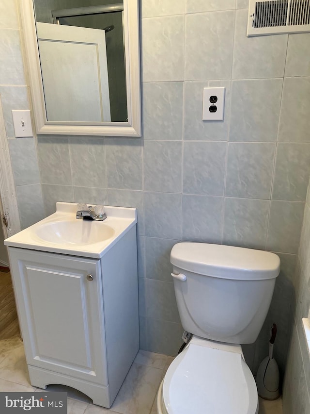 bathroom with tile floors and tile walls