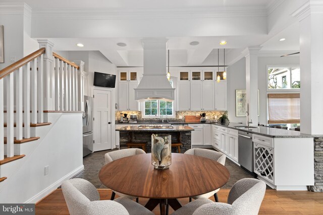164 W Lake Dr, Annapolis, MD 21403 - dining room featuring plenty of natural light, wood-type flooring, decorative columns, and ornamental molding