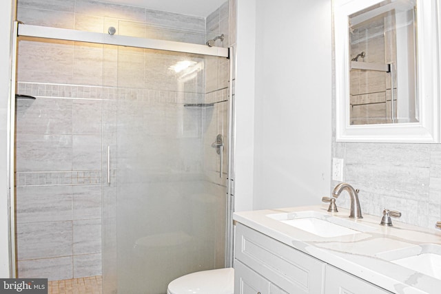 bathroom with toilet, large vanity, and an enclosed shower