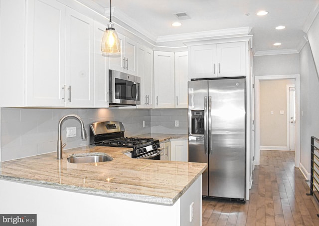 kitchen featuring light stone countertops, kitchen peninsula, backsplash, appliances with stainless steel finishes, and white cabinets