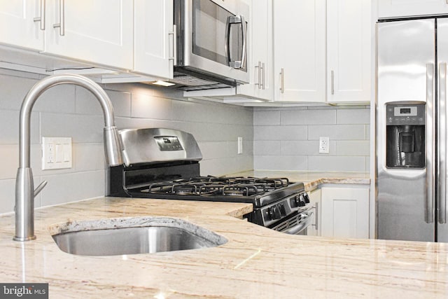 kitchen with appliances with stainless steel finishes, light stone countertops, and tasteful backsplash