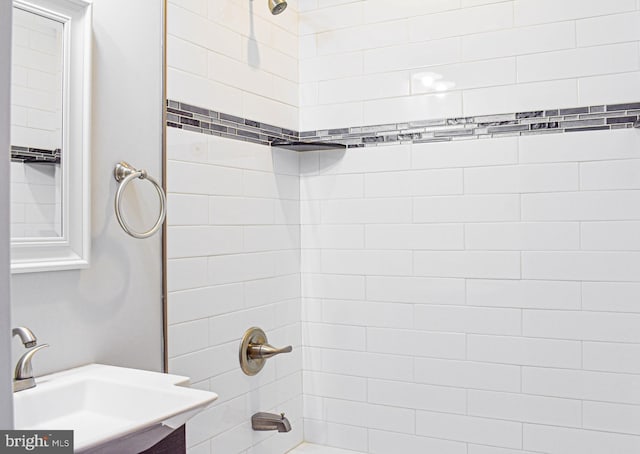 bathroom with tiled shower / bath and vanity