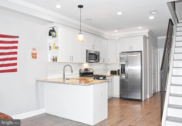 kitchen with light stone countertops, tasteful backsplash, stainless steel appliances, and wood-type flooring