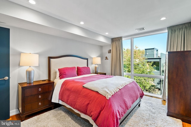 bedroom with light hardwood / wood-style floors and a wall of windows