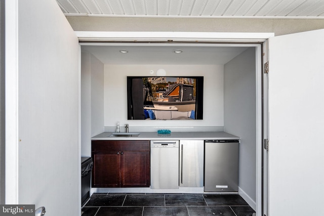 interior details featuring dark tile floors, dishwashing machine, vanity, and dishwasher