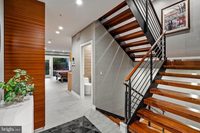 stairs featuring billiards and light tile floors