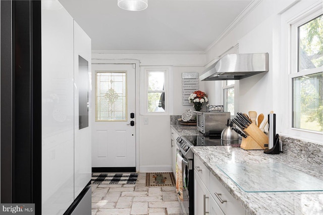 kitchen featuring electric range, white cabinetry, a wealth of natural light, and wall chimney range hood