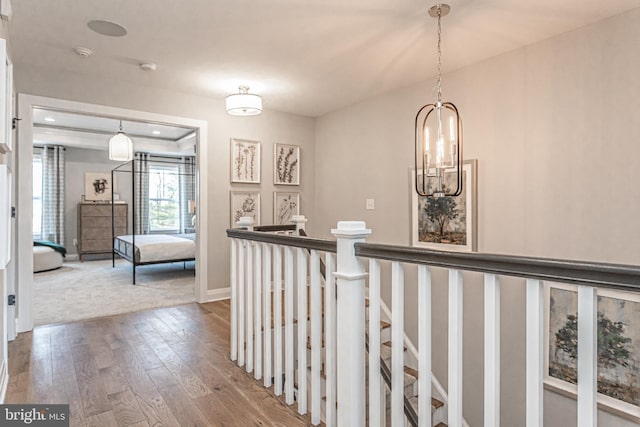 hall featuring light hardwood / wood-style floors and an inviting chandelier