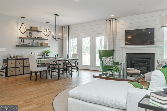 living room featuring light hardwood / wood-style flooring and an inviting chandelier