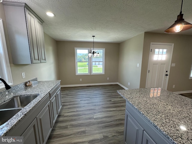 kitchen featuring dark hardwood / wood-style floors, a healthy amount of sunlight, and light stone countertops
