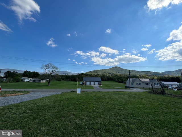 view of yard with a mountain view and a garage