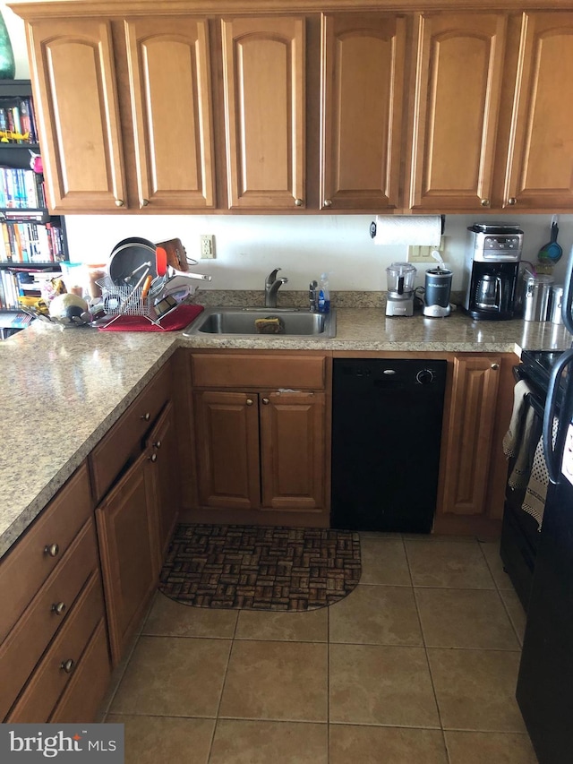 kitchen featuring range, light stone counters, dark tile floors, dishwasher, and sink