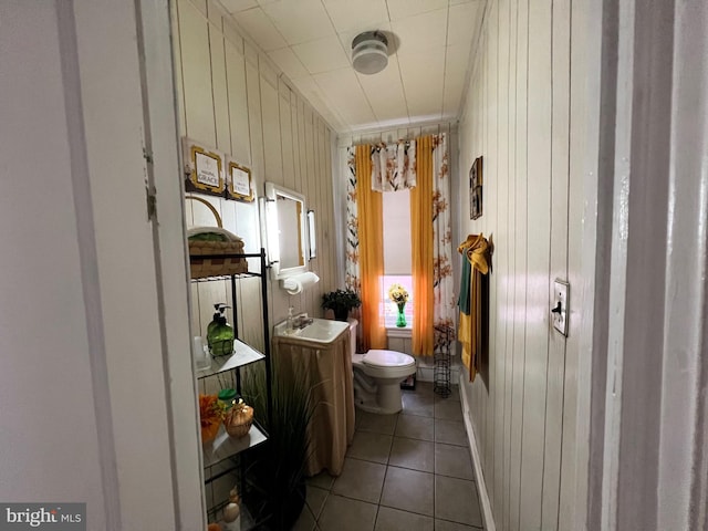 bathroom featuring wood walls, tile patterned flooring, vanity, and toilet