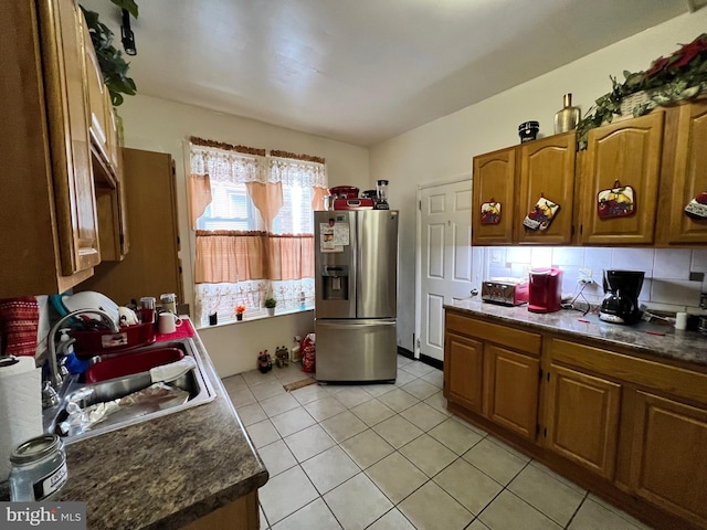 kitchen featuring decorative backsplash, stainless steel fridge with ice dispenser, sink, and light tile patterned floors