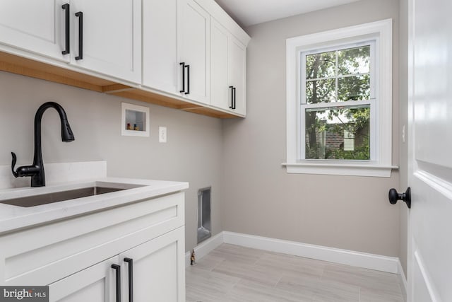 clothes washing area with cabinets, washer hookup, electric dryer hookup, and sink