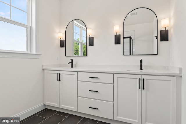 bathroom with tile patterned floors, vanity, and a wealth of natural light