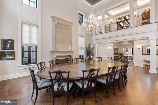 dining room featuring dark parquet flooring, a towering ceiling, and an inviting chandelier