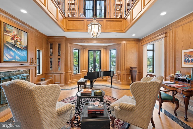 living room with light wood-type flooring, wooden walls, and a premium fireplace