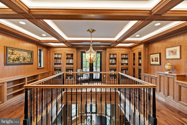 interior space with beam ceiling, wood walls, and coffered ceiling