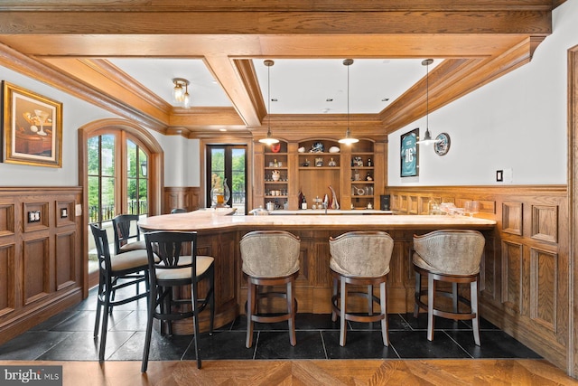 bar with french doors, ornamental molding, beam ceiling, decorative light fixtures, and built in features