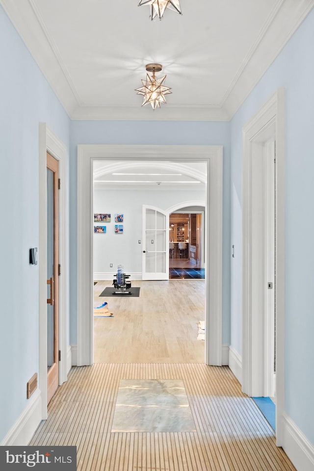 hall featuring light hardwood / wood-style flooring and ornamental molding