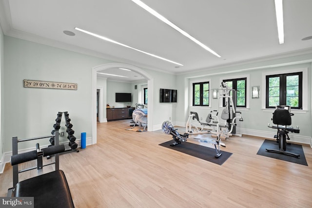 exercise room featuring ornamental molding, french doors, and light hardwood / wood-style flooring