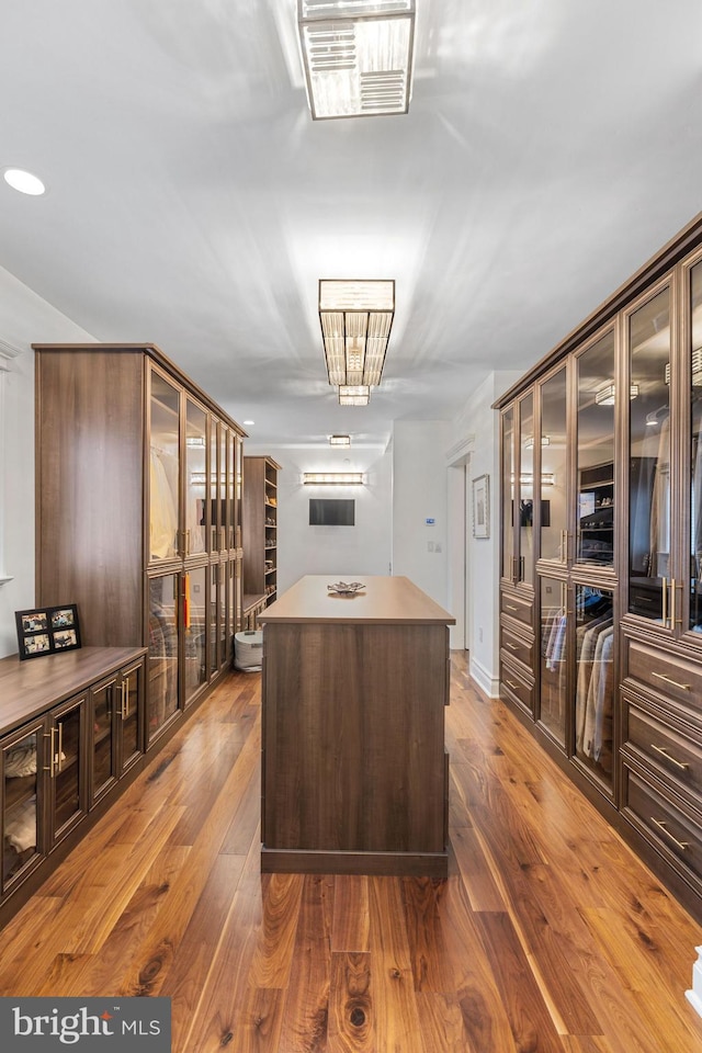 interior space featuring wood-type flooring, a center island, and dark brown cabinetry