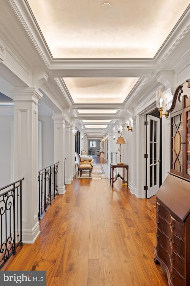 hall with ornamental molding and light hardwood / wood-style flooring