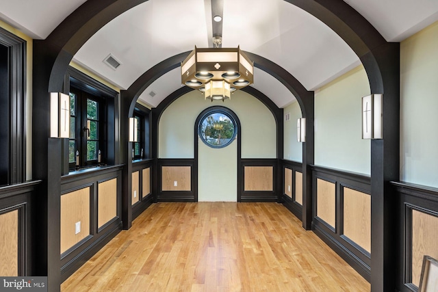 hall featuring light hardwood / wood-style flooring and lofted ceiling