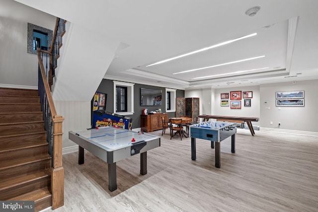 rec room featuring a tray ceiling and light hardwood / wood-style flooring