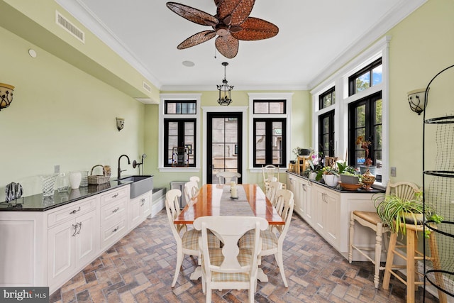 dining space with sink, french doors, ceiling fan, and ornamental molding