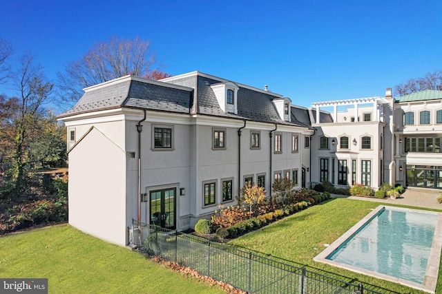 back of house featuring a yard and a fenced in pool