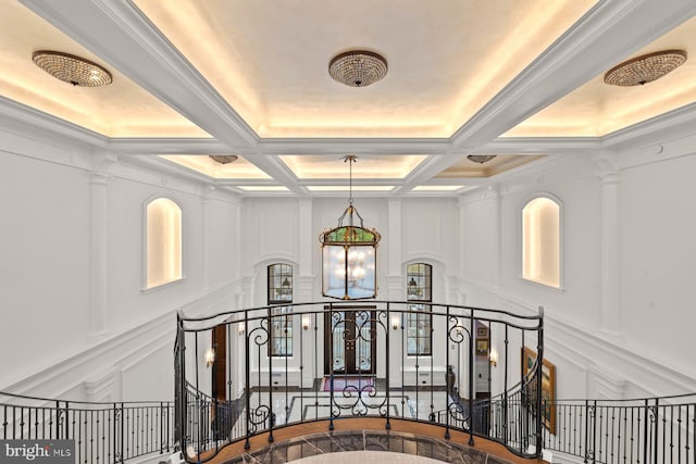 hall with beamed ceiling, a notable chandelier, and coffered ceiling