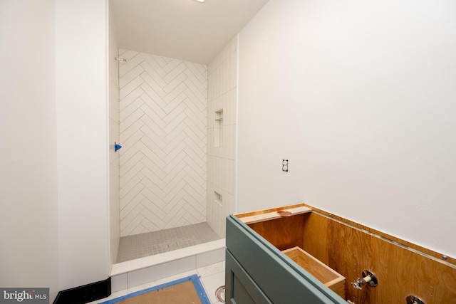 bathroom with a tile shower and tile patterned floors