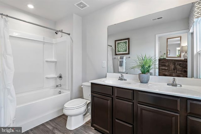 full bathroom featuring wood-type flooring, shower / bath combination with curtain, vanity, and toilet