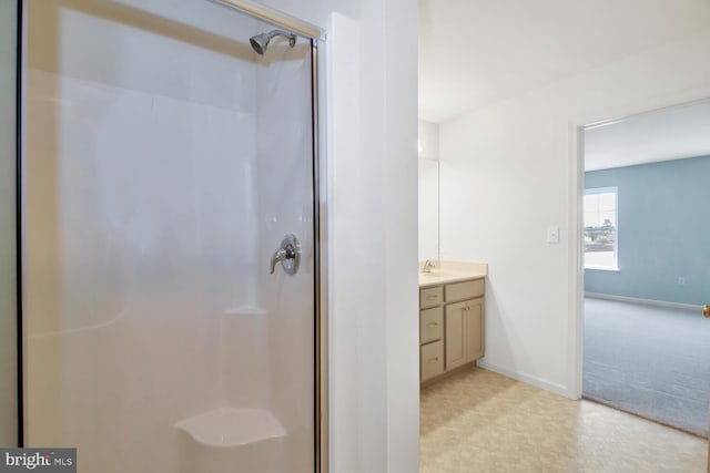 bathroom with a shower with shower door and vanity