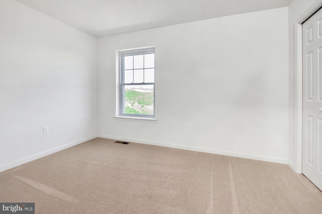 carpeted spare room featuring a healthy amount of sunlight