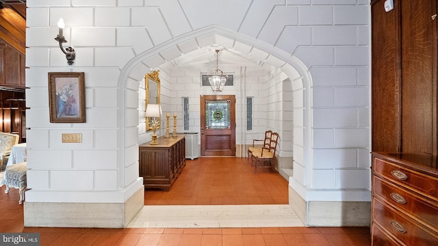 interior space with a notable chandelier, lofted ceiling, and light wood-type flooring