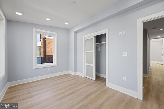 unfurnished bedroom with a closet and light hardwood / wood-style floors