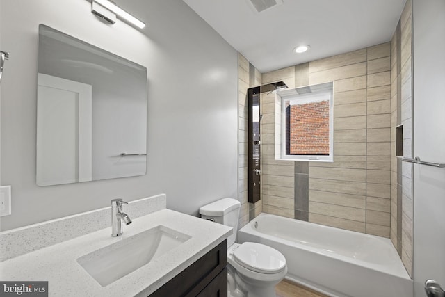 full bathroom with tiled shower / bath combo, vanity, and toilet