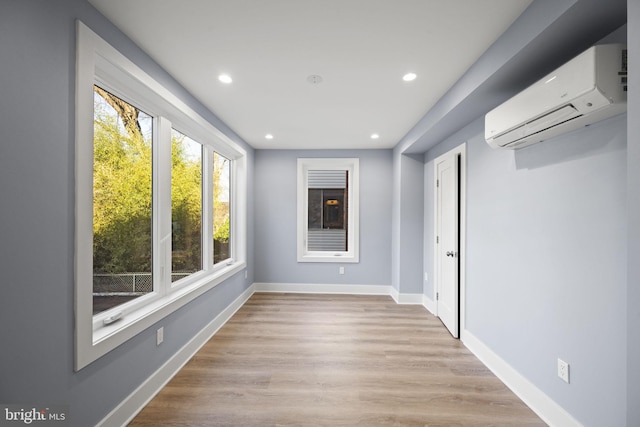 interior space with a wall unit AC and light wood-type flooring