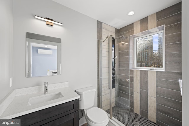 bathroom with vanity, toilet, and a shower with shower door