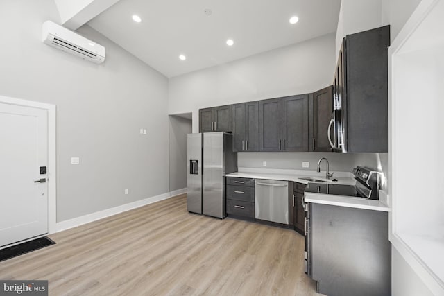 kitchen with light hardwood / wood-style flooring, sink, stainless steel appliances, and a wall mounted air conditioner