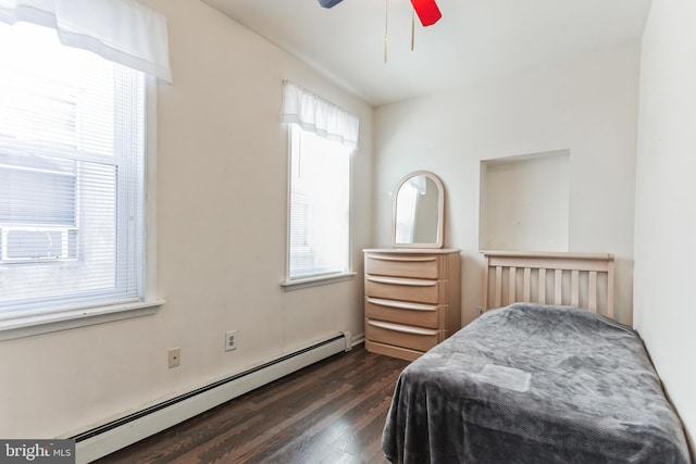 bedroom featuring ceiling fan, dark wood-type flooring, and a baseboard heating unit