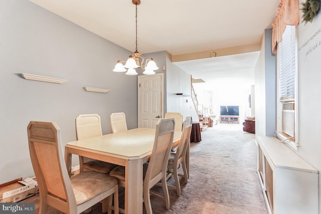 dining area featuring light colored carpet and a chandelier