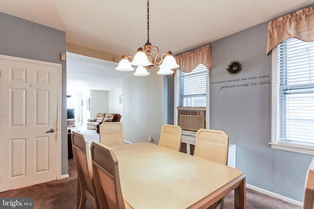 dining area featuring a chandelier and dark carpet